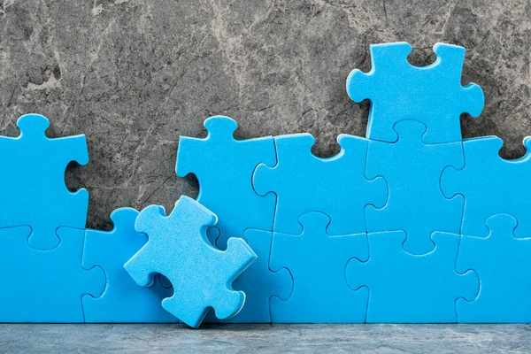 Onafgewerkte Blauwe Legpuzzelstukjes Grijze Cementondergrond Team Business Concept — Stockfoto