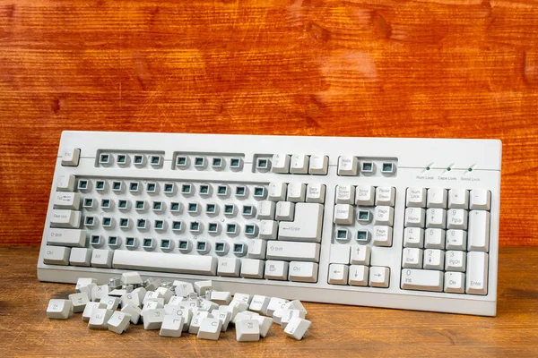 壊れたキーボードの横にある削除されたキーボードキーのヒープ — ストック写真