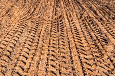 Tire tread marks. The texture of the tire tracks on the clay.Heavy vehicle tire tracks. Traces on the construction site.  clipart