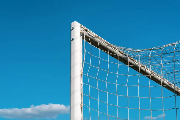 Top left corner of a football goal against blue sky