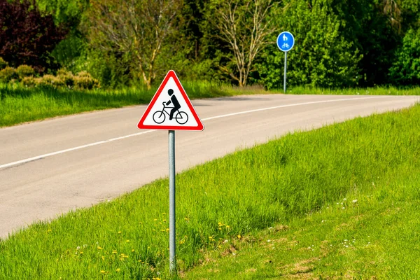Warning symbol in a red triangle. Bicycle traffic sign on a country road.Cycle route ahead.