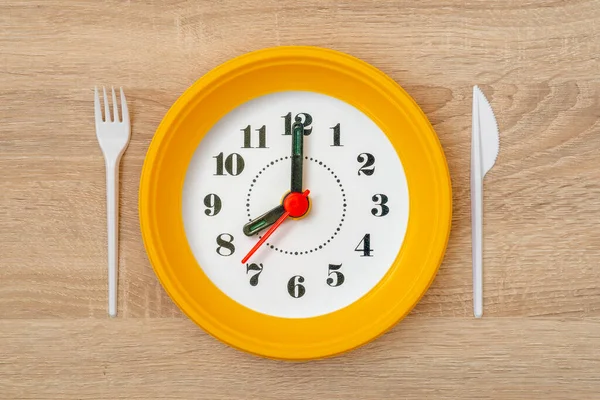 時計の顔と使い捨ての黄色のプレート 朝食の時間 — ストック写真