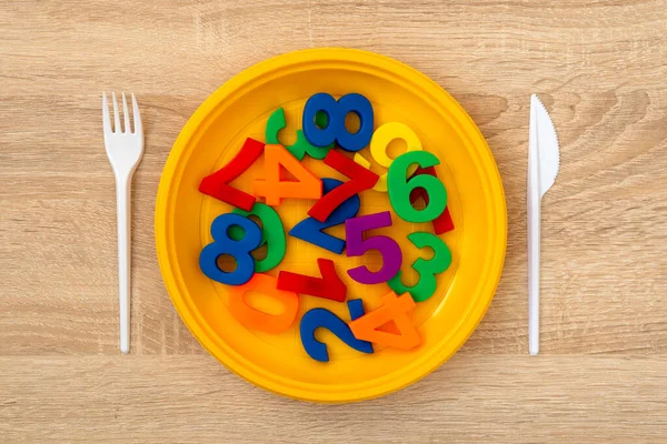 Fork, knife and plate with colored numbers. Hungry for education,knowledge, brain feeding concept.