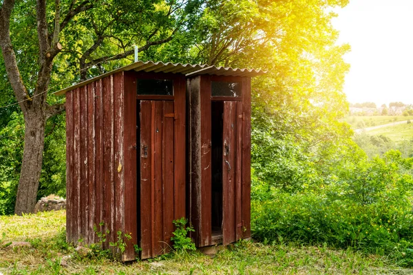 Couple of old wooden toilets in the woods. Outhouse in the wood.