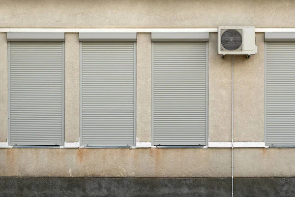 stock image Industrial house facade with air conditioner compressor and metal blinds on windows