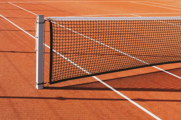 Tennis net on the court background.Empty tennis court in the park on sunny day.
