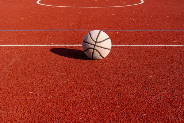 都市裁判所のよく着用されたバスケットボールボール 晴れた日の公園の空のバスケットボールコート ストック画像