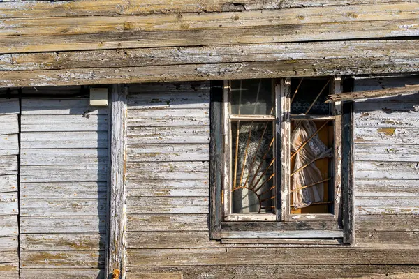 金属グリッド付きの古い壊れた窓 放棄された木造家屋の壁 ストック画像