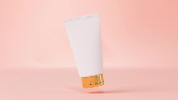 Plastik Kosmetik Krim Tabung Mockup Mengapung Berputar Pada Merah Muda — Stok Video