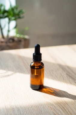Kahverengi kehribar rengi serum serumu yağ düşürücü şişesi ve beyaz havlu. Masa maketi, kozmetik konteynır gerçek iç mekan, bakım ürünü şablonu.