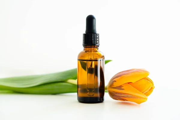 Amber Glas Cosmetische Druppelaar Fles Oranje Tulp Bloemen Geïsoleerd Witte Stockfoto