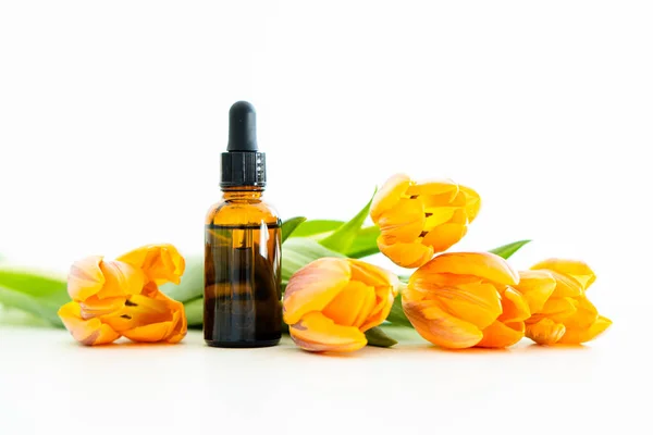 Amber Glas Cosmetische Druppelaar Fles Oranje Tulp Bloemen Geïsoleerd Witte Stockfoto