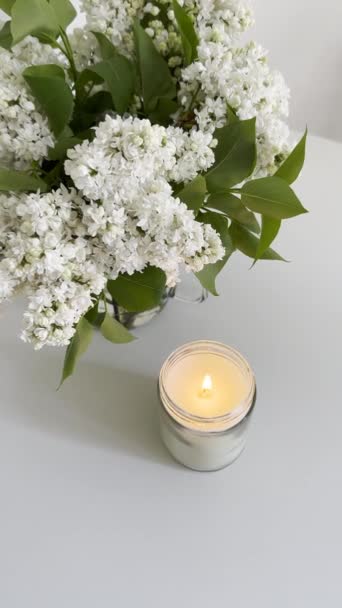 Bougie Brûlante Pot Verre Clair Bouquet Lilas Blanc Sur Table — Video