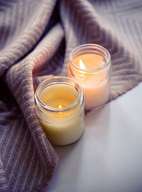 Mumlar ve yumuşak bir battaniyeyle rahat ve sıcak bir ortam, rahatlatıcı ve huzurlu bir atmosfer yaratıyor..