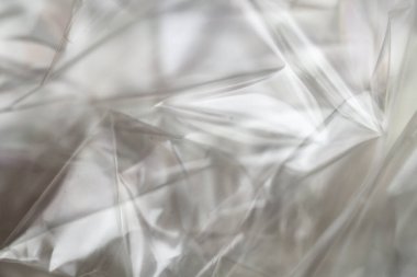 Buruşuk berrak plastik arka plan, soyut parlak kırık yüzey dokusu kırışıklıklar, yakın çekim