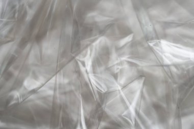 Buruşuk berrak plastik arka plan, soyut parlak kırık yüzey dokusu kırışıklıklar, yakın çekim