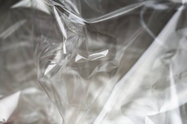 Buruşuk berrak plastik arka plan, soyut parlak kırık yüzey dokusu kırışıklıklar, yakın çekim