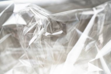 Buruşuk berrak plastik arka plan, soyut parlak kırık yüzey dokusu kırışıklıklar, yakın çekim