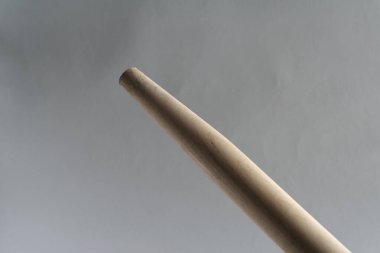 Küreğin tahta sapı. Gri bir arkaplanda.