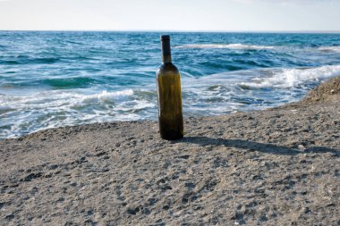 Hazar Denizi 'nin kayalık kıyısında bir şişe şarap..