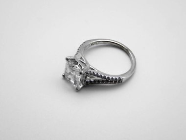 Beyaz arkaplan üzerine yakın plan taşlı gümüş bir yüzük.