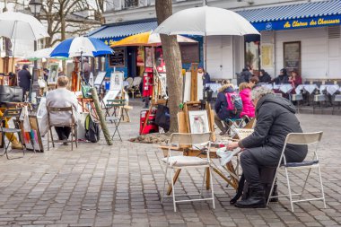 Paris, Fransa - 6 Mart 2023: Montmartre mahallesinde yürüyen insanlar. Geleneksel bölge sanatçıları, kafeleri, restoranları ve gece hayatıyla ünlüdür..