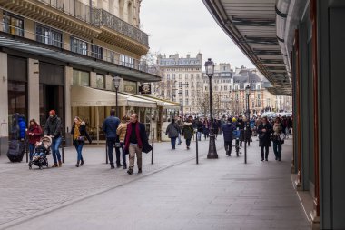 Paris, Fransa - 6 Mart 2023: Paris 'in birinci arrondissement bölgesindeki La Monnaie caddesinde yürüyen insanlar. Louvre olarak da bilinen arrondissement, birçok lüks mağazaya ev sahipliği yapar..