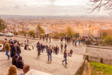 Paris, Fransa - 6 Mart 2023: Sacre Coeur katedrali yakınlarındaki Montmartre mahallesinde yürüyen insanlar. Geleneksel bölge sanatçıları, kafeleri, restoranları ve gece hayatıyla ünlüdür..