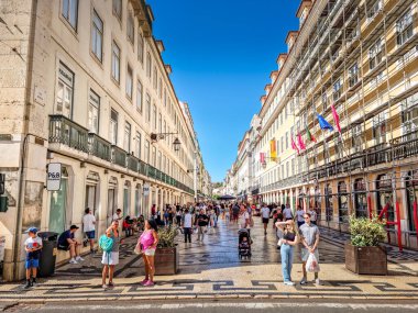 Lizbon, Portekiz - 27 Ağustos 2023: Augusta Caddesi 'nde yürüyen insanlar. Yaya caddesi geleneksel kaldırım taşı tasarımlarıyla döşelidir ve restoran, kafe ve dükkanlarla doludur..