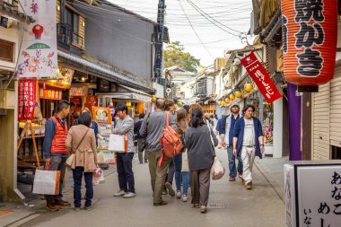 Miyajima Adası, Japonya - 13 Nisan 2019: Eski kentte yürüyen insanlar. Bölge stokları ve yiyecekleriyle ünlüdür..