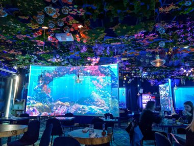 Paris, Fransa - 6 Mart 2023: Deniz altı restoranında masa ve ekranlar. Ani açılan restoran sualtı atmosferi yaratıyor..