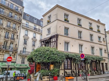 Paris, Fransa - 6 Mart 2023: Montmartre mahallesinde yürüyen insanlar. Geleneksel bölge sanatçıları, kafeleri, restoranları ve gece hayatıyla ünlüdür..