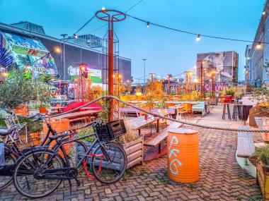 Amsterdam, Netherlands - 23 October, 2023: Bicybles by a bar in the NDSM Amsterdam. The neighborhood is famous for its arts, restaurants and festivals.