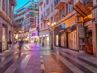 San Remo, İtalya - 19 Mayıs 2024: Geceleri şehir merkezinde yürüyen insanlar. Şehir, Sanremo Müzik Festivali ve MilanSan Remo bisiklet klasiği gibi çok sayıda kültürel etkinliğe ev sahipliği yapmaktadır..