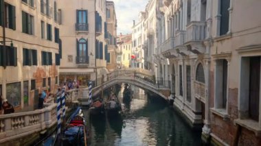 Venedik, İtalya... 20 Ağustos 2024: Kanalda gondolların tadını çıkaran turistler. Gondollar şehirdeki en popüler ve romantik ulaşım araçlarıdır..