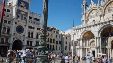 Venedik, İtalya... 20 Ağustos 2024: Saint Marks meydanında yürüyen turistler. Aynı zamanda La Piazza olarak da bilinir. St Mark Bazilikası ve iki Venedik simgesi olan Campanile 'in bulunduğu yerdir..
