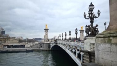 Paris, Fransa - 5 Mart 2023: İnsanlar Alexandre III köprüsünde yürüyor. Geleneksel cazibe şehrin en gösterişli ve abartılı köprüsü olarak bilinir..