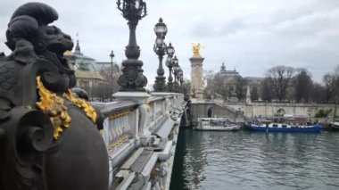 Paris, Fransa - 5 Mart 2023: İnsanlar Alexandre III köprüsünde yürüyor. Geleneksel cazibe şehrin en gösterişli ve abartılı köprüsü olarak bilinir..