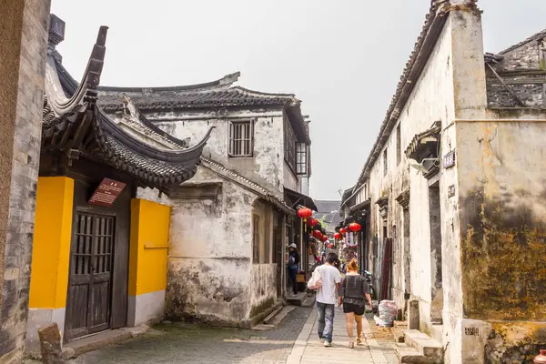 Suzhou, Çin - 4 Nisan 2011: Pazar caddesinde yürüyen turistler. Suzhou genellikle 