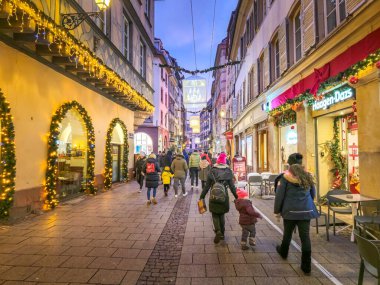 Strasbourg, Fransa - 31 Aralık 2024: İnsanlar Noel için şehir merkezinde yürüyor. Tatil döneminde şehre her yıl yaklaşık 2 milyon ziyaretçi gelir..