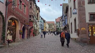 Riquewihr, Fransa - 03 Ocak 2025: Tatil için dekore edilmiş eski kentte yürüyen insanlar. Köy Noel pazarı ve şarabıyla ünlüdür..