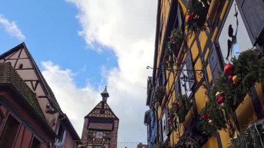 Riquewihr, Fransa - 03 Ocak 2025: Tatil için dekore edilmiş eski kentte yürüyen insanlar. Köy Noel pazarı ve şarabıyla ünlüdür..
