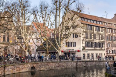 Strasbourg, Alsace, France - 31 December, 2024: People walking in the Petite France. The district is known for its cobbled streets, canals and well-preserved half-timbered houses. clipart