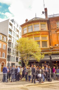 Londra, İngiltere - 13 Mayıs 2011: İnsanlar şehir merkezindeki tipik bir barın önünde içki içiyorlar. Bar ismi halk evinden geliyor ve İngiliz kültürünün temelinde bir içki müessesesi..