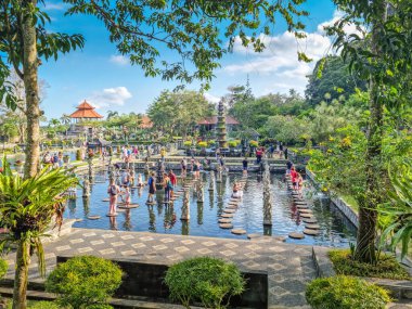 Bali, Endonezya - 16 Ağustos 2024: Tirta Gangga Sarayı 'nda yürüyen insanlar. Burası Karangasem kraliyet su sarayı, banyo havuzları ve Patirthan tapınağı olarak bilinir..