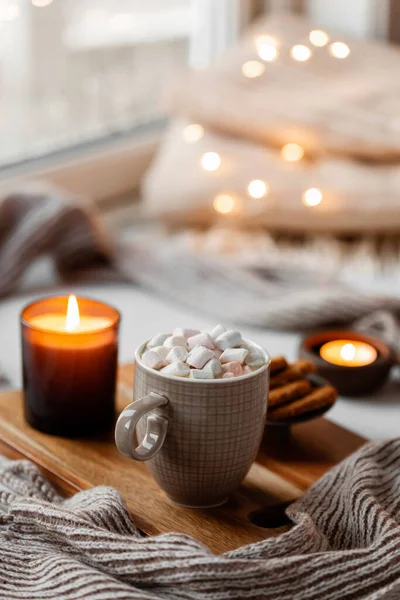 warm cozy window arrangement, winter or autumn concept, coffe, candles throw lights