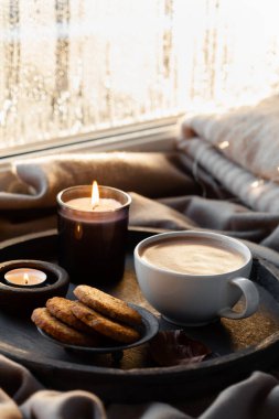 Sıcak bir pencere düzenleme, kış ya da sonbahar konsepti, kahve, mumlar ışık saçar. 