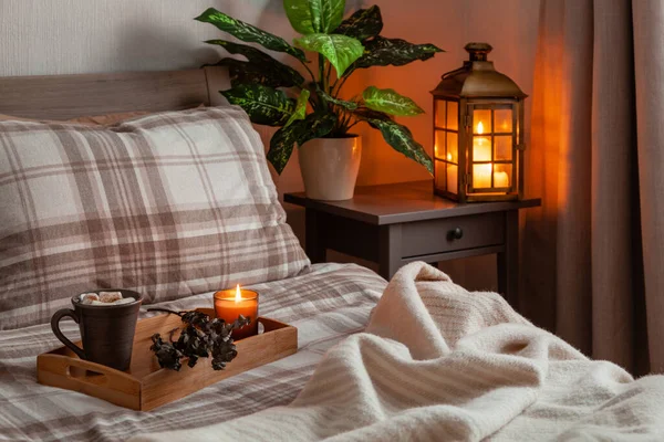 cozy scandinavian bedroom interior in natural tones, blanket lantern houseplants