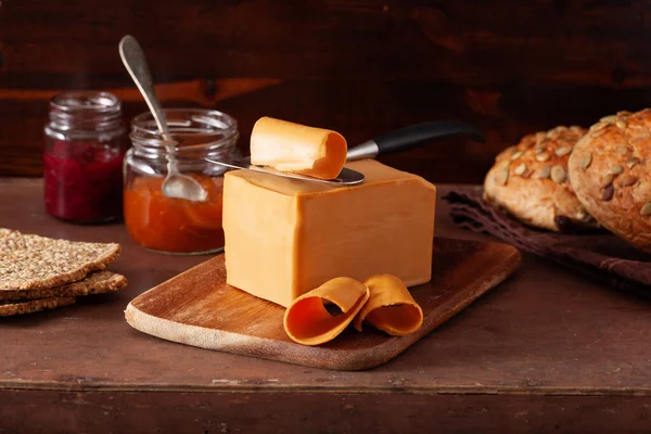 挪威人在乡村背景下吃传统的褐色奶酪 — 图库照片