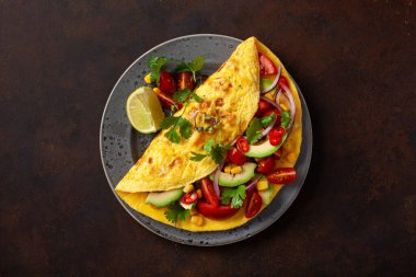 Domatesli omlet, avokado soğanlı biber ve tatlı mısır. Sağlıklı keto diyeti düşük karbonhidratlı kahvaltı